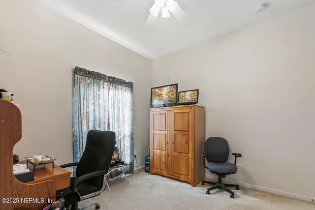 a view of a workspace with furniture and a window