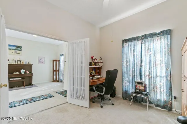 a view of a workspace with furniture and a window