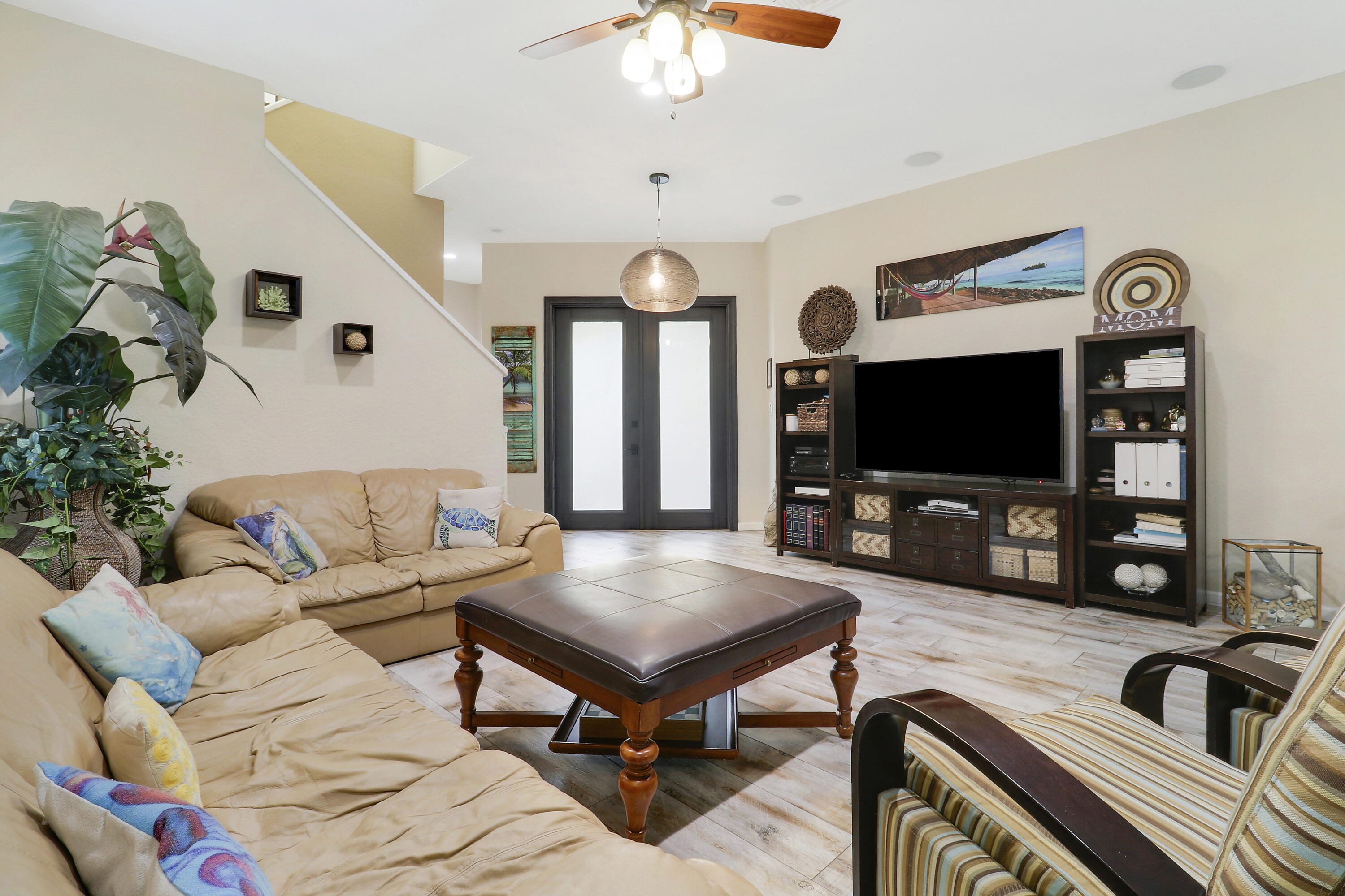 104 Via Azurra Jupiter, FL 33458 - Photo 16 of 41 a living room with furniture a flat screen tv and a chandelier