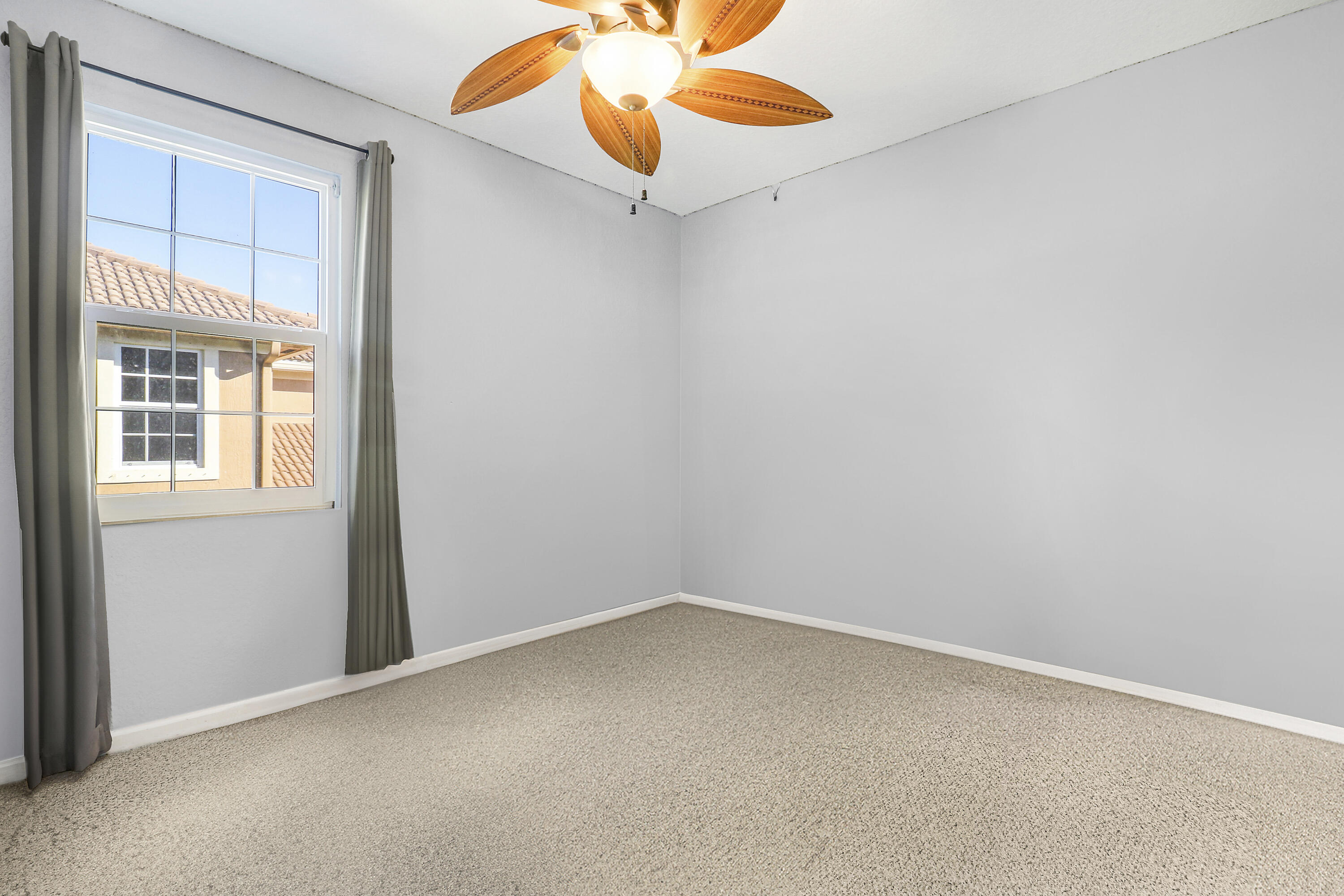 104 Via Azurra Jupiter, FL 33458 - Photo 33 of 41 an empty room with a window and a chandelier fan