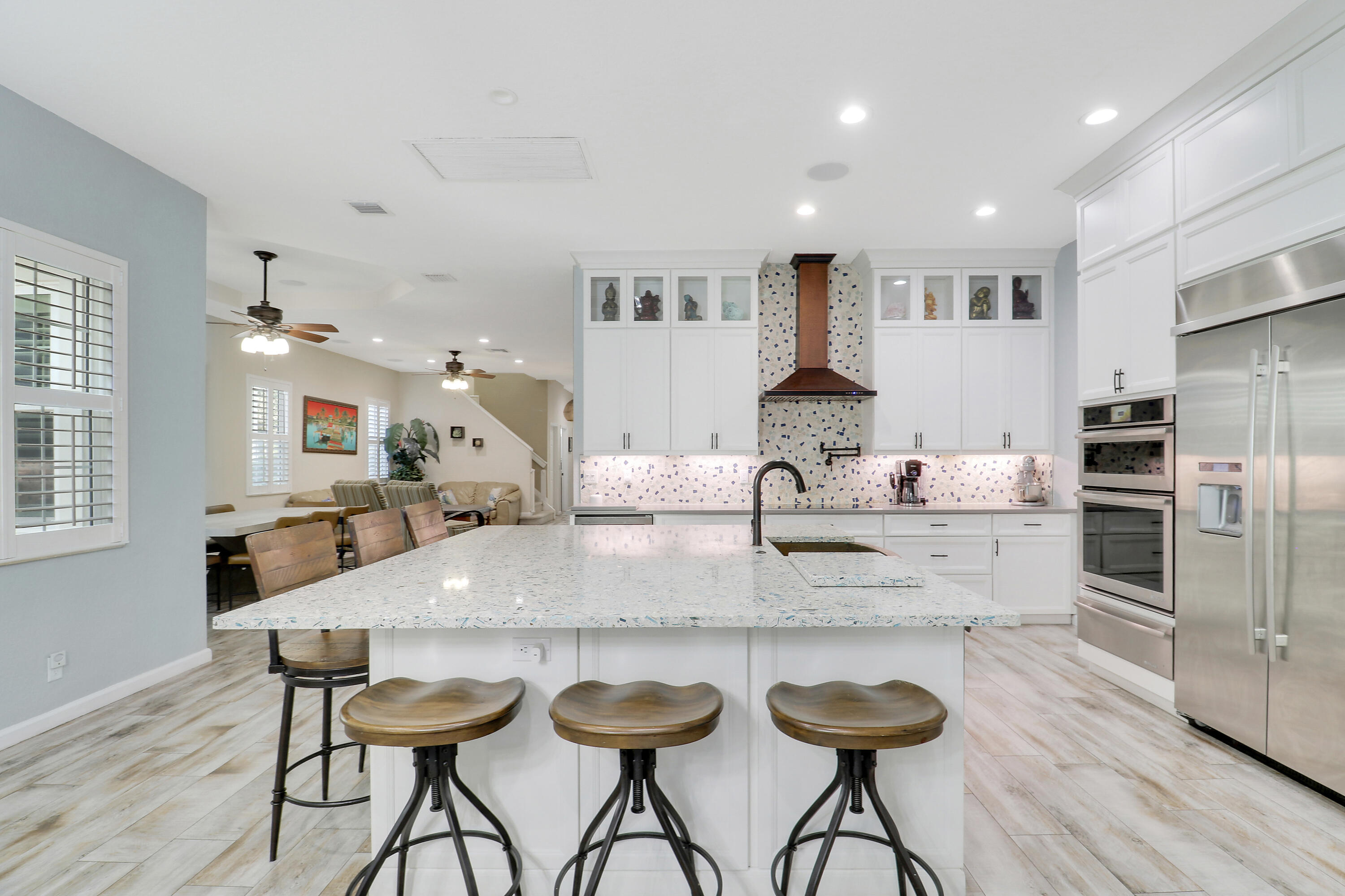 104 Via Azurra Jupiter, FL 33458 - Photo 5 of 41 a kitchen with stainless steel appliances kitchen island granite countertop a kitchen island and chairs in it