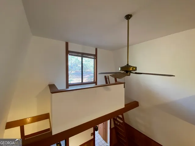 a bedroom with a bed and a chandelier fan