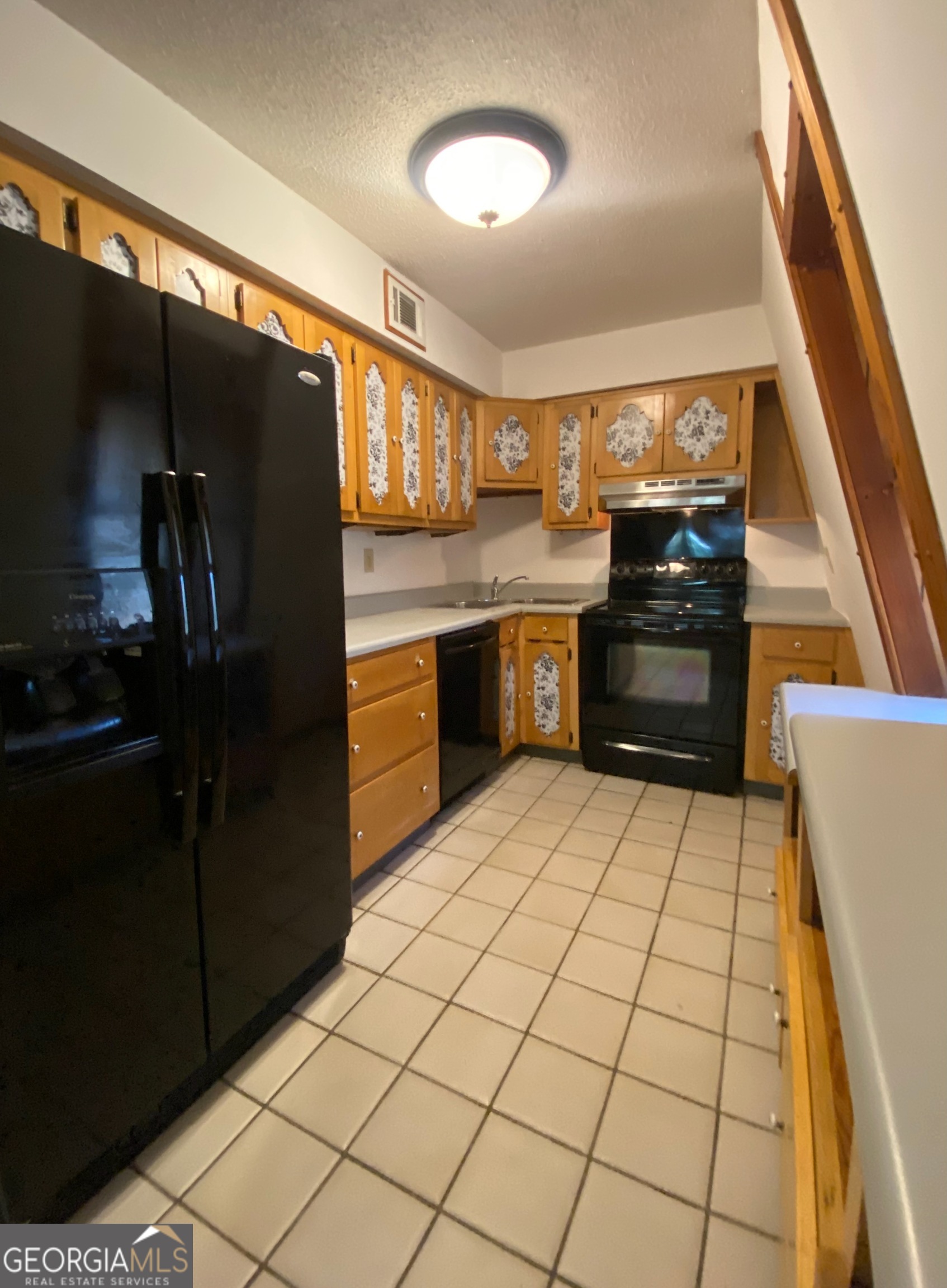 231 West Seminole Drive Byron, GA 31008 - Photo 7 of 38 a kitchen with granite countertop a refrigerator and a stove top oven