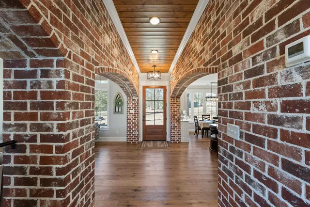 a view of a hallway with wooden floor and a chandelier
