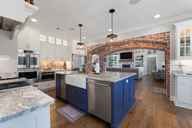 a kitchen with stove a refrigerator and chairs
