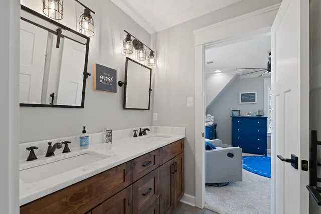 a en suite bathroom with a double vanity sink a mirror and shower