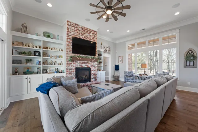 a living room with furniture a fireplace and a flat screen tv