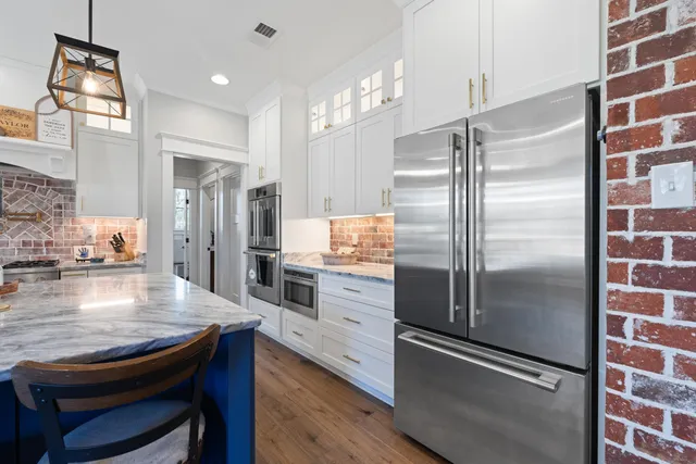 a kitchen with kitchen island a counter top space stainless steel appliances and cabinets