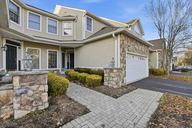 a view of a white house with large windows and a tree