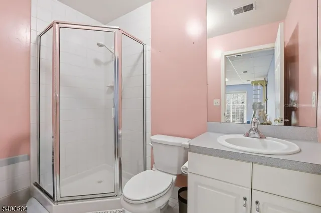 a bathroom with a sink a mirror a toilet and shower