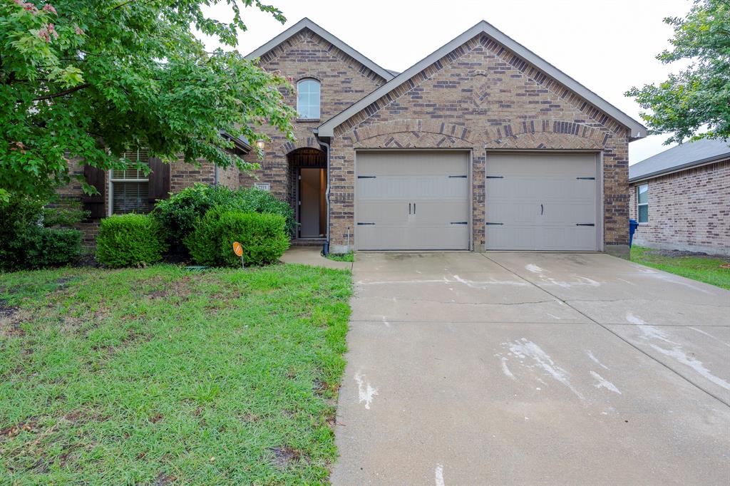 View of front facade with a garage, concrete driveway, and brick siding