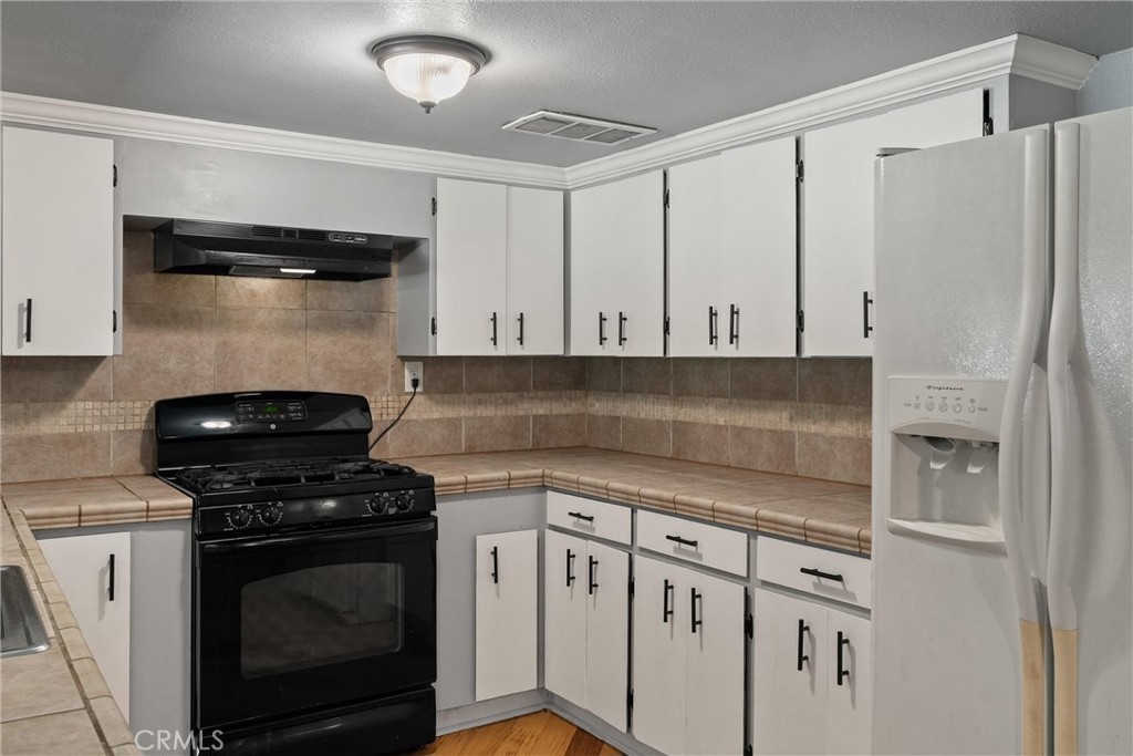 5150 Miners Ranch Road Oroville, CA 95966 - Photo 12 of 36 a kitchen with granite countertop white cabinets and stainless steel appliances