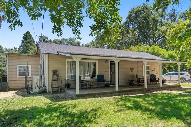 a view of a house with backyard porch and sitting area