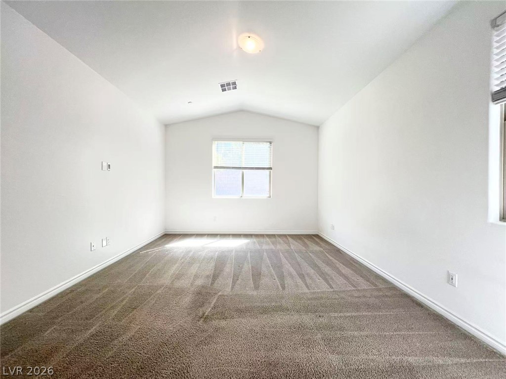 925 Bayberry Ridge Street Henderson, NV 89052 - Photo 7 of 27 A well-lit, neutral-toned room with vaulted ceilings and ample natural light from the window.