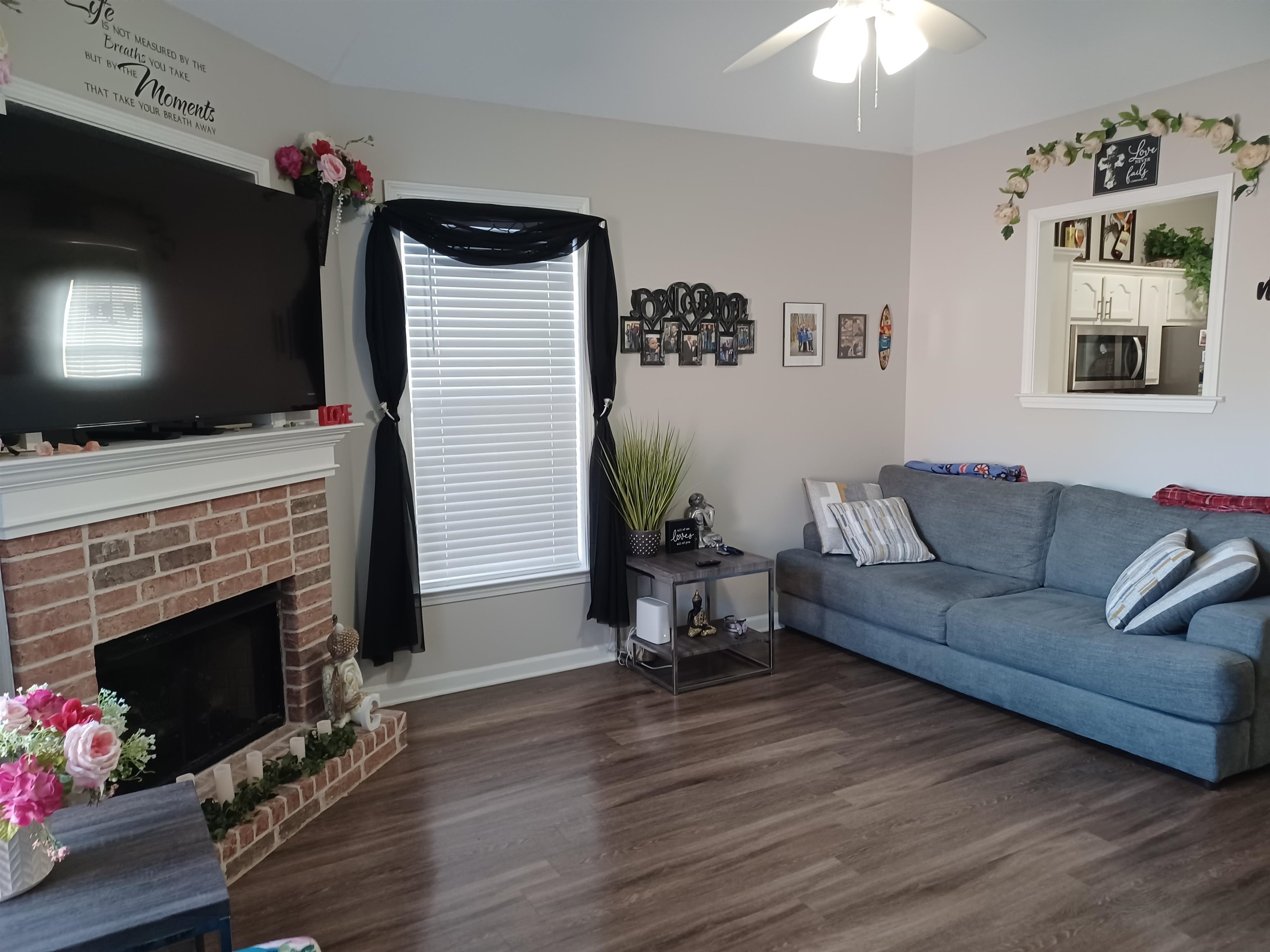 8700 Macon Road Memphis, TN 38018 - Photo 3 of 18 a living room with furniture a flat screen tv and a fireplace