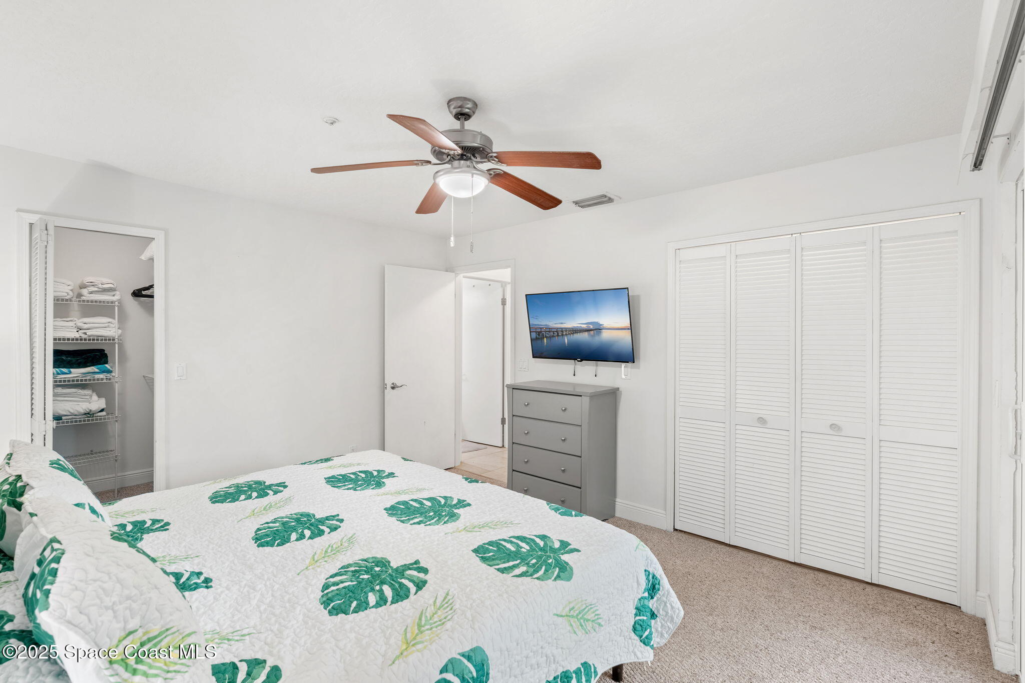 7667 North Wickham Road, Unit 518 Melbourne, FL 32940 - Photo 12 of 34 a bedroom with a bed and a flat screen tv
