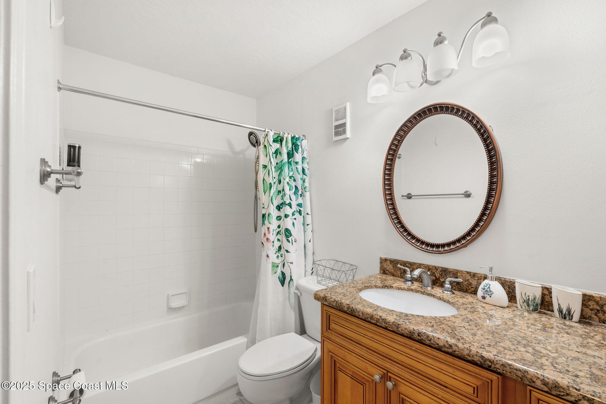 7667 North Wickham Road, Unit 518 Melbourne, FL 32940 - Photo 15 of 34 a bathroom with a granite countertop sink mirror vanity and toilet