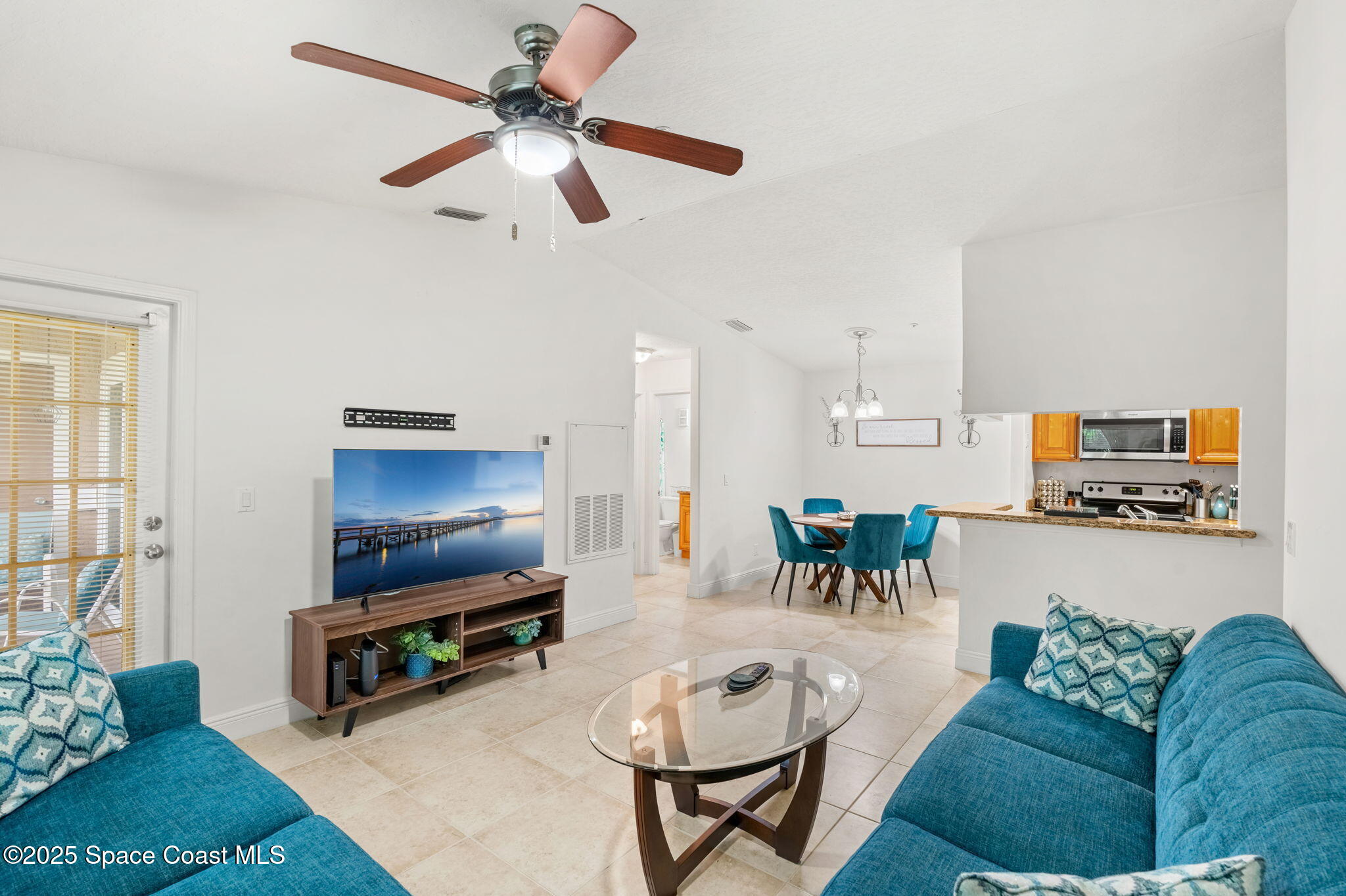 7667 North Wickham Road, Unit 518 Melbourne, FL 32940 - Photo 17 of 34 a living room with furniture a flat screen tv and a window
