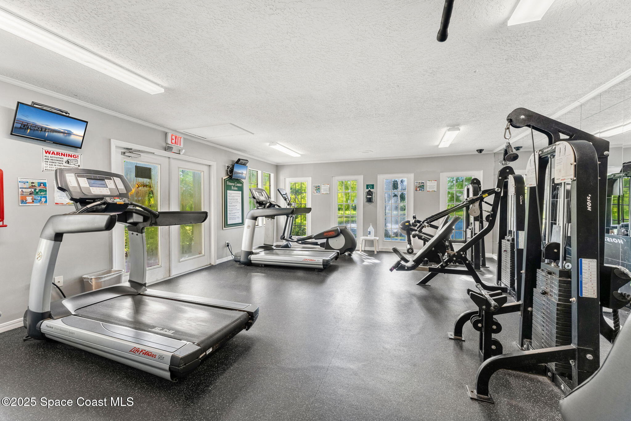7667 North Wickham Road, Unit 518 Melbourne, FL 32940 - Photo 25 of 34 a room with gym equipment and windows