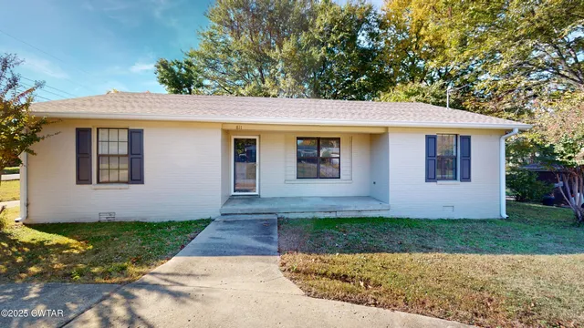 a front view of a house with a yard and potted plants