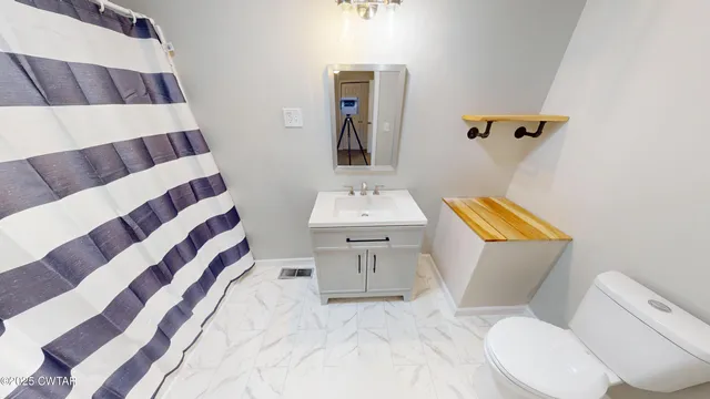 a bathroom with a sink toilet and mirror