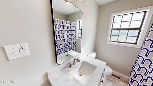 a bathroom with a sink a toilet and mirror