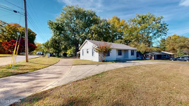a view of swimming pool with outdoor seating and trees in the background