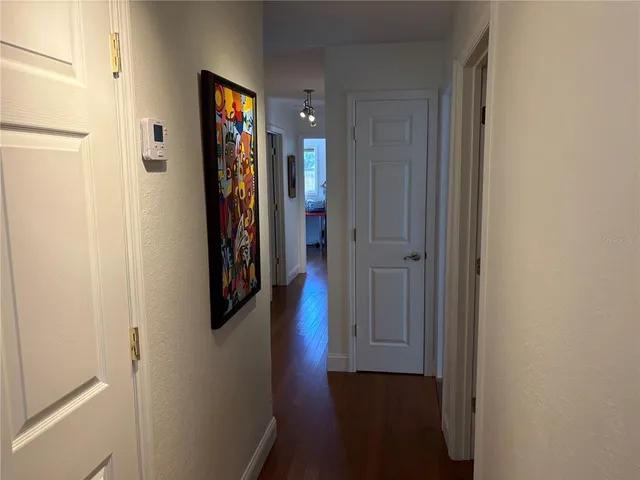 a view of a hallway with wooden floor and closet