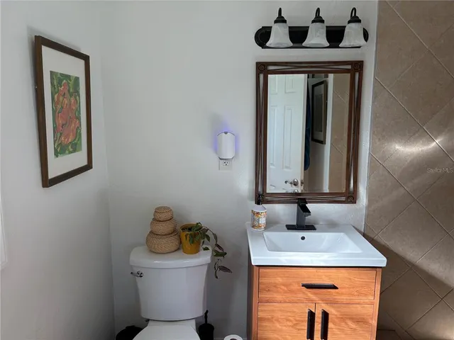 a bathroom with a sink toilet and mirror
