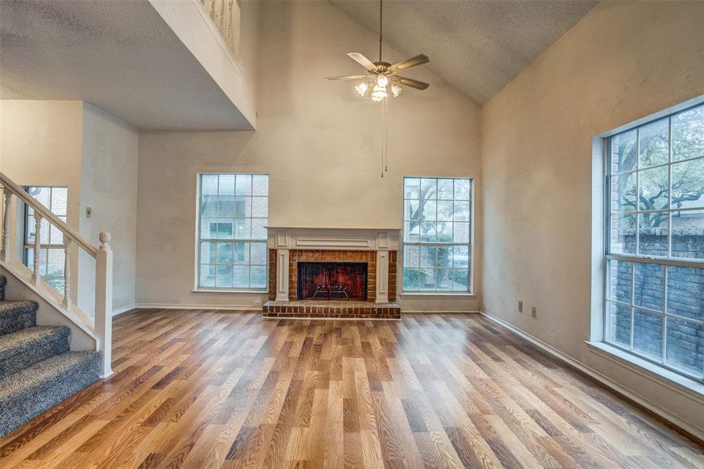 wooden floor fireplace and windows in an empty room