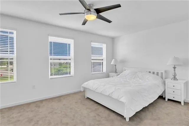 a bedroom with a bed a chandelier and a window