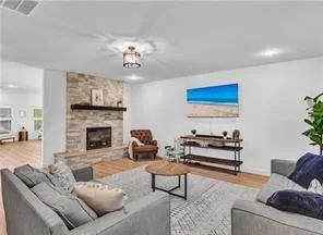 a living room with furniture a fireplace and a chandelier