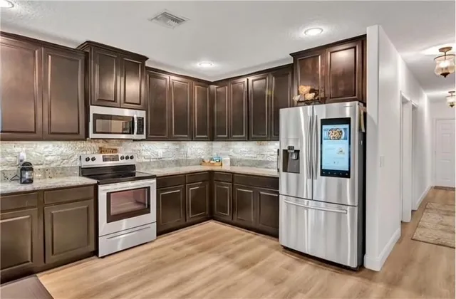a kitchen with granite countertop stainless steel appliances and wooden cabinets