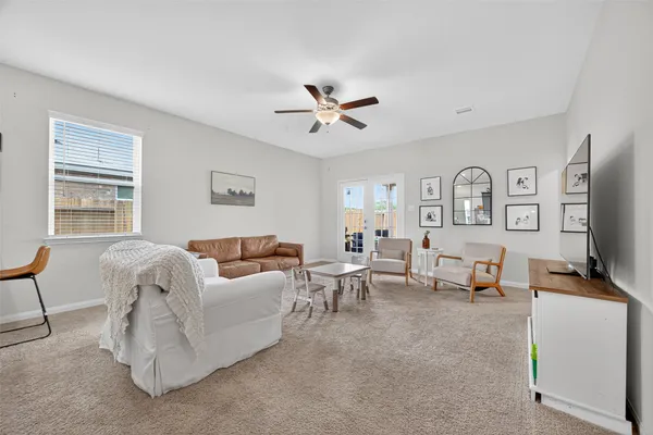 a living room with furniture two window and a flat screen tv