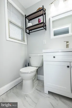 a bathroom with a toilet a sink and a mirror