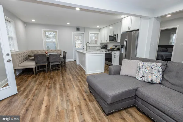 a living room with furniture and a dining table with kitchen view