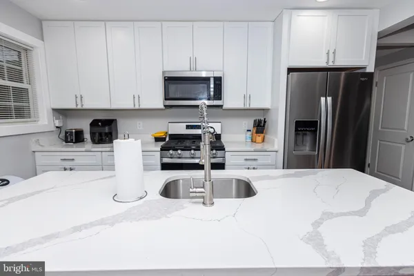 a kitchen with stainless steel appliances granite countertop a refrigerator sink and stove