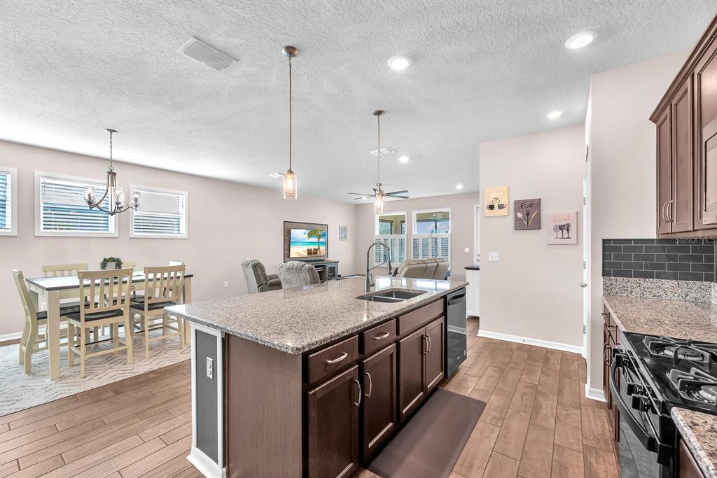 6230 Plover Meadow Street Lithia, FL 33547 - Photo 13 of 50 a kitchen with a table chairs stove and wooden floor