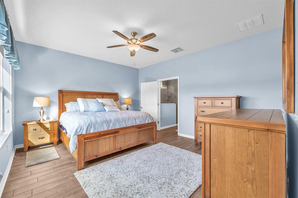 6230 Plover Meadow Street Lithia, FL 33547 - Photo 21 of 50 a bedroom with a bed and a chandelier