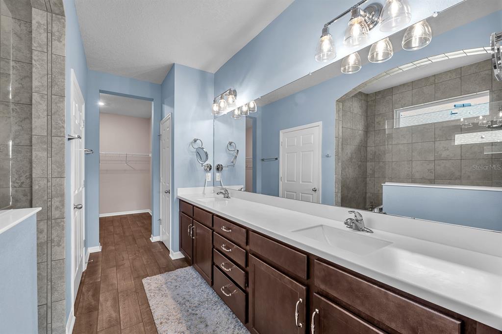 6230 Plover Meadow Street Lithia, FL 33547 - Photo 23 of 50 a spacious bathroom with a double vanity sink a mirror and a shower
