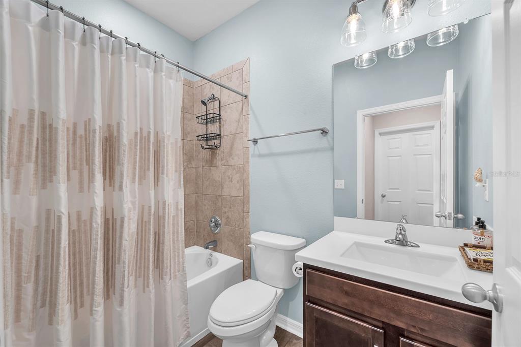 6230 Plover Meadow Street Lithia, FL 33547 - Photo 28 of 50 a bathroom with a sink a toilet and shower curtain