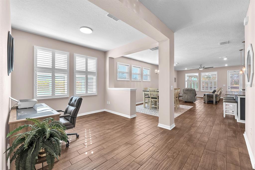 6230 Plover Meadow Street Lithia, FL 33547 - Photo 7 of 50 a workspace with furniture wooden floor and a kitchen