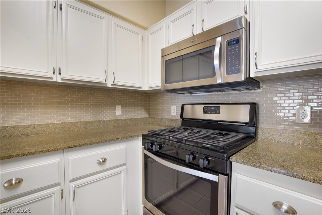 10550 West Alexander Road, Unit 2171 Las Vegas, NV 89129 - Photo 9 of 17 Gleaming stone countertops and classic cabinetry frame the modern cooking area.