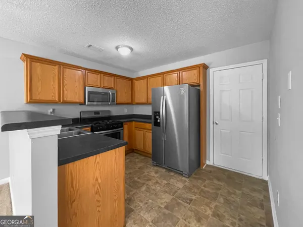 a kitchen with a refrigerator and a stove top oven