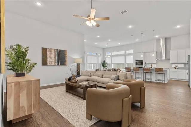 a living room with furniture kitchen view and a chandelier