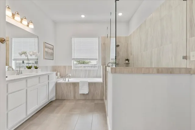 a bathroom with a granite countertop sink mirror and a bathtub