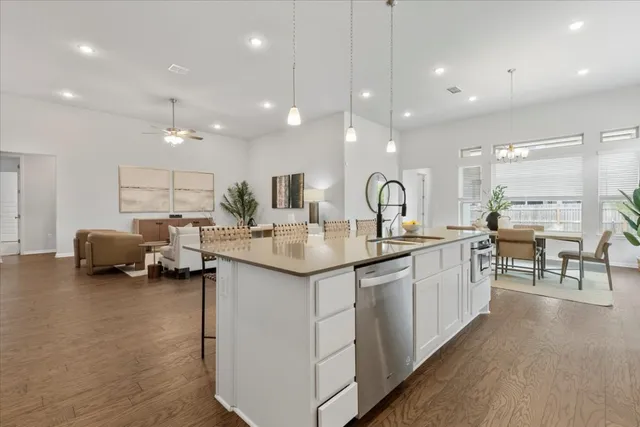 a large kitchen with kitchen island a sink appliances and a counter top space