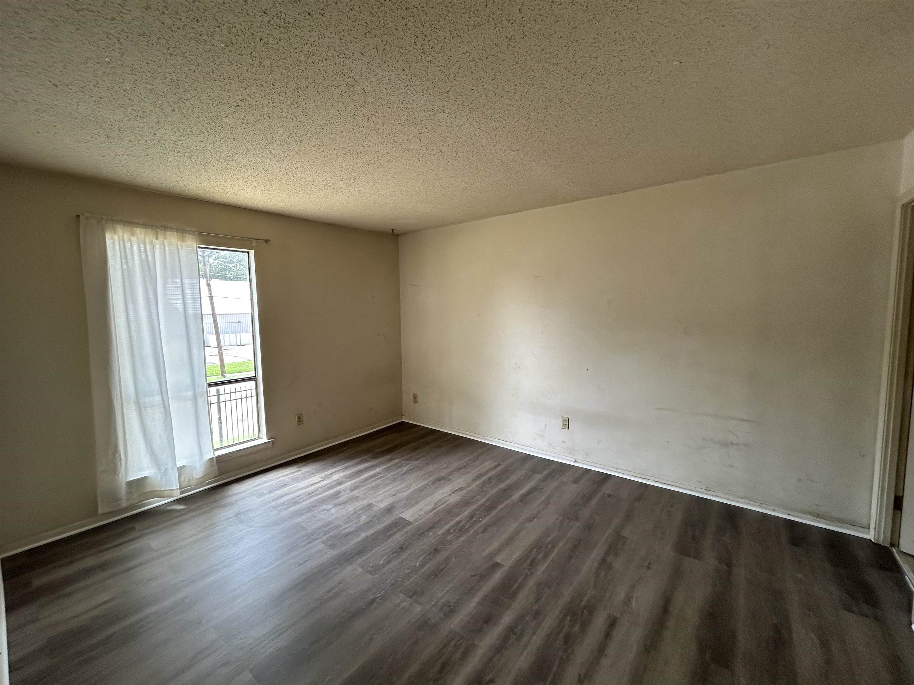 2800 Clarke Road, Unit 2 Memphis, TN 38115 - Photo 12 of 18 Spacious interior featuring wood-finish flooring, light-colored walls, and a window with a metal security grill