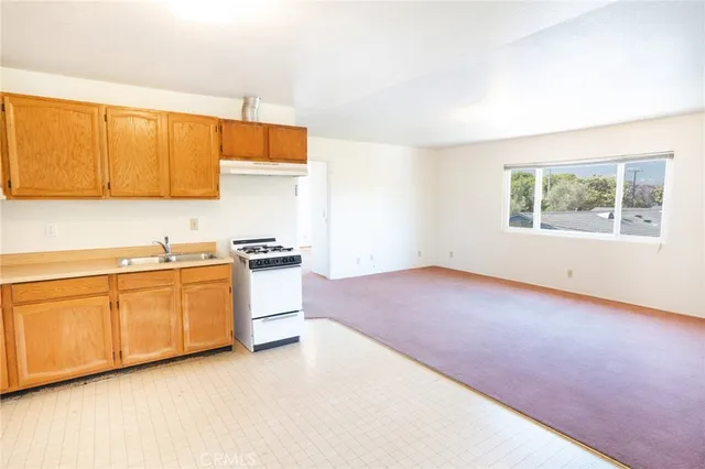 a view of a kitchen with a sink and a refrigerator