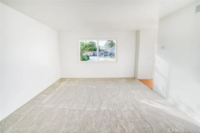 a view of a big room with wooden floor and a window